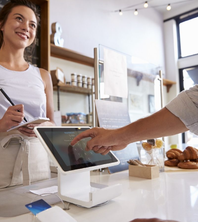 Customer using touch screen to make payment at a coffee shop